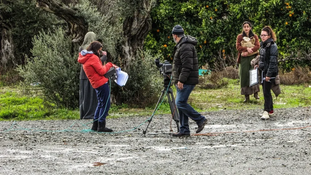 Over-the-shoulder shot of a camera operator filming a scene